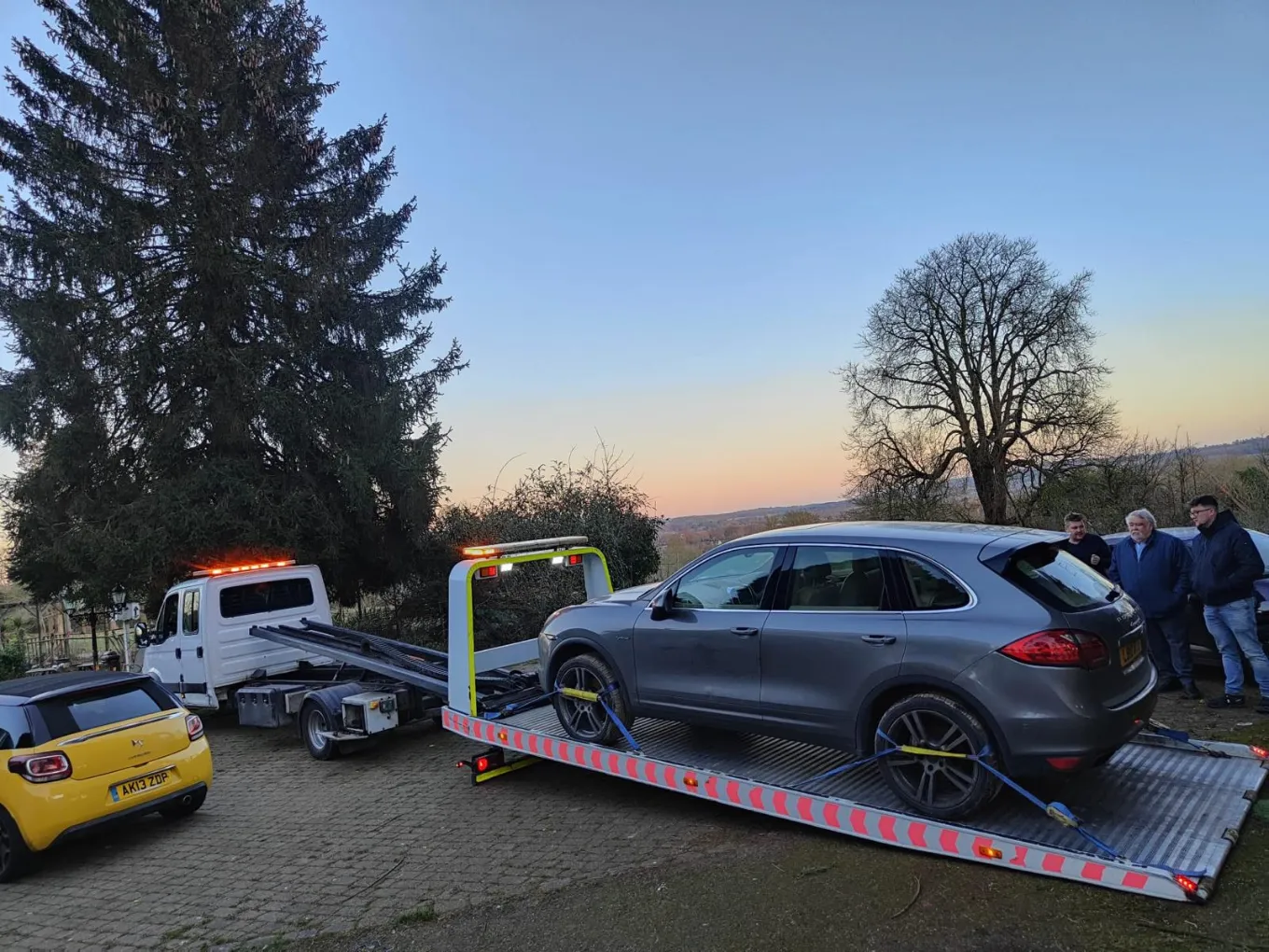 gray luxury SUV secured on a flatbed tow truck